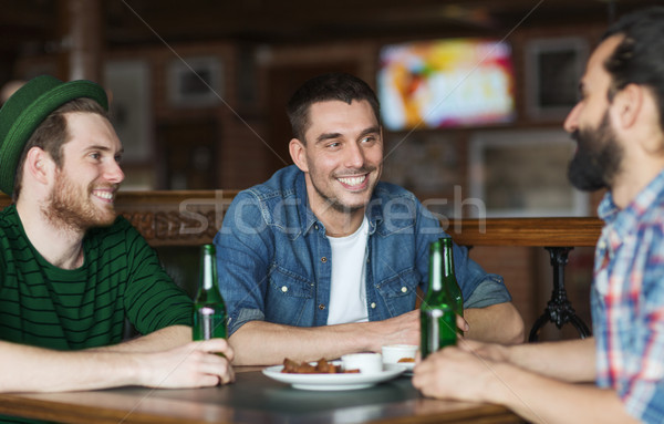 Stock photo: happy male friends drinking beer at bar or pub