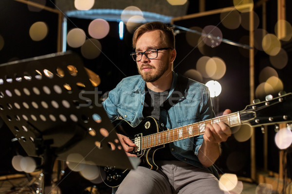 man playing guitar at studio rehearsal Stock photo © dolgachov