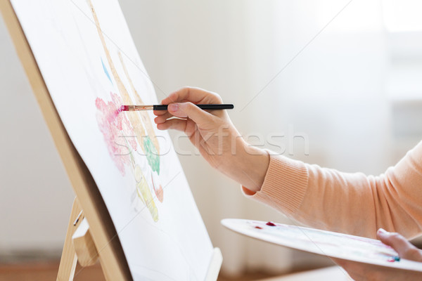 artist with palette and brush painting at studio Stock photo © dolgachov