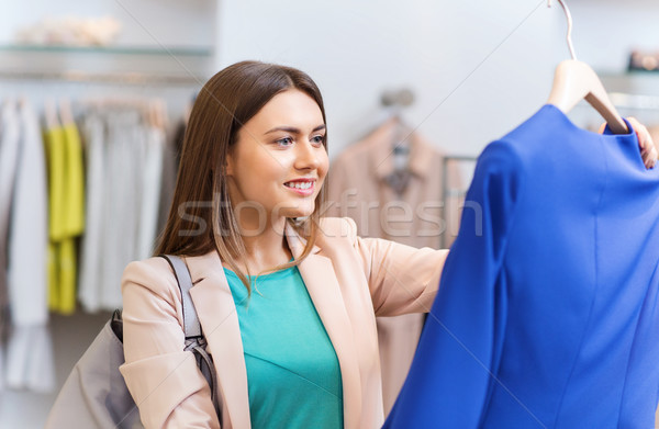 happy young woman choosing clothes in mall Stock photo © dolgachov