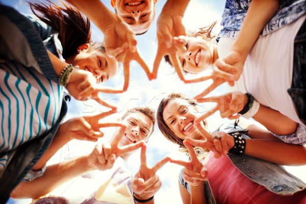 group of teenagers showing finger five Stock photo © dolgachov