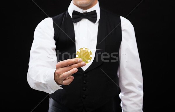 dealer holding golden poker chip Stock photo © dolgachov