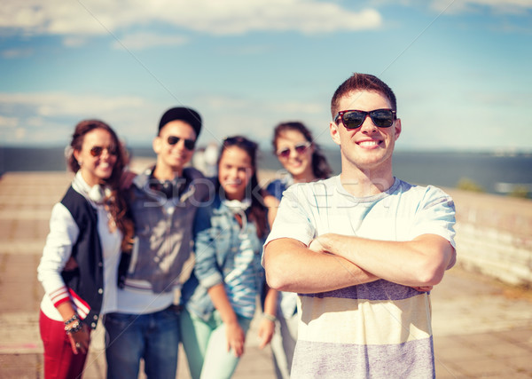 Stock photo: teenage boy with sunglasses and friends outside