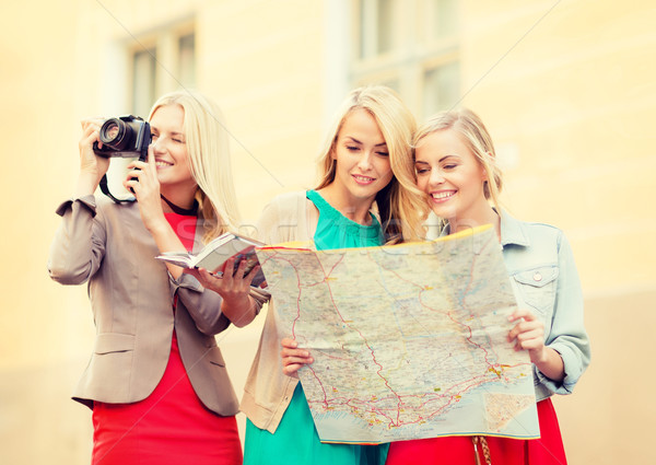 women with tourist map and camera in the city Stock photo © dolgachov