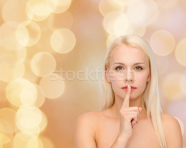calm young woman with finger on lips Stock photo © dolgachov