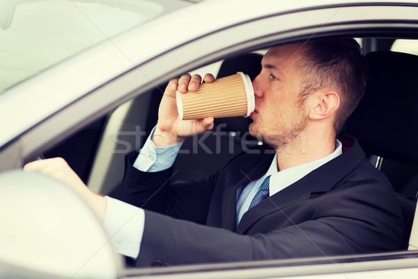 Stock photo: man drinking coffee while driving the car