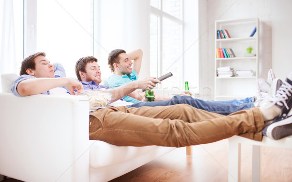 happy male friends with beer watching tv at home Stock photo © dolgachov