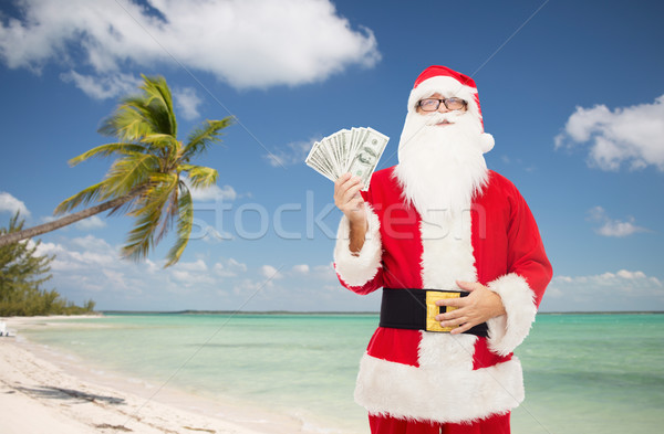 man in costume of santa claus with dollar money Stock photo © dolgachov