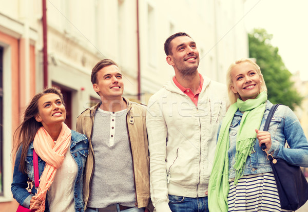 group of smiling friends walking in the city Stock photo © dolgachov