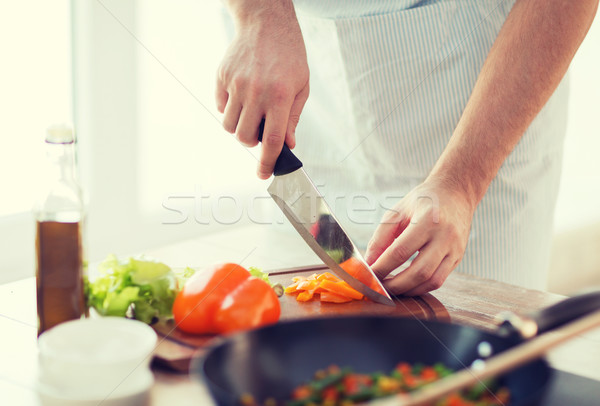 close up of male hand cutting pepper on board Stock photo © dolgachov