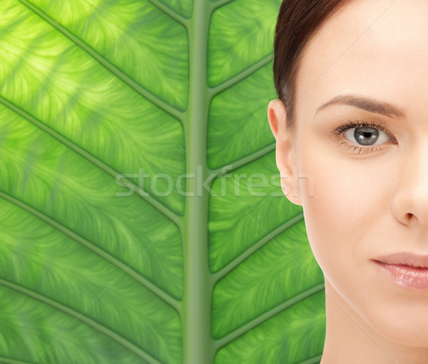young woman face over green leaf background Stock photo © dolgachov
