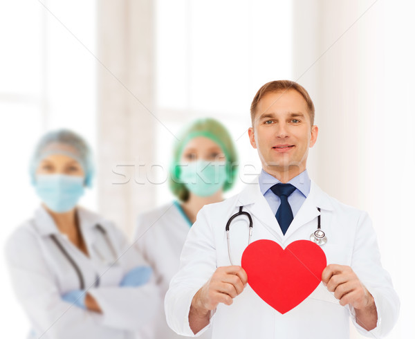 smiling male doctor with red heart and stethoscope Stock photo © dolgachov