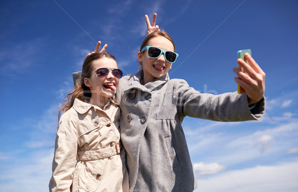happy girls with smartphone taking selfie outdoors Stock photo © dolgachov