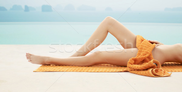 close up of woman legs with orange towel on beach Stock photo © dolgachov