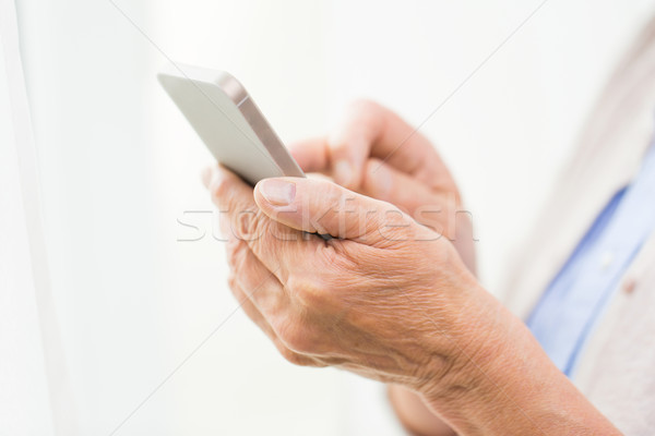 close up of senior woman with smartphone texting Stock photo © dolgachov