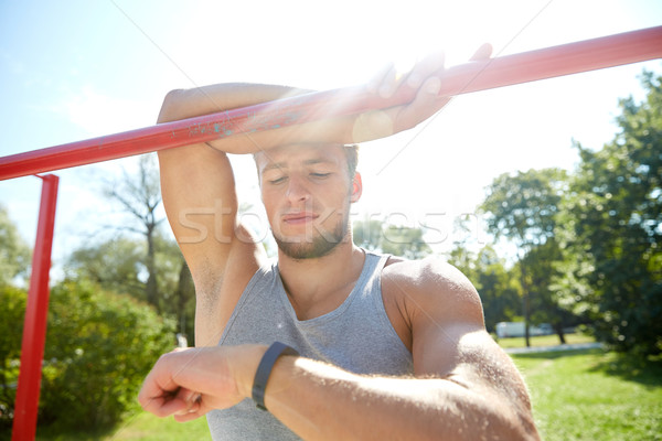 man with heart-rate watch exercising outdoors Stock photo © dolgachov