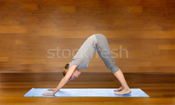 woman making yoga dog pose on mat Stock photo © dolgachov