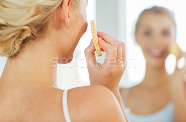 close up of woman washing face with sponge at home Stock photo © dolgachov