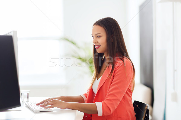 happy african woman with computer at office Stock photo © dolgachov