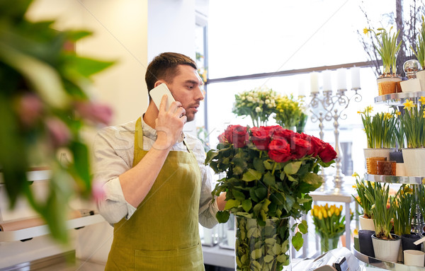 Stock photo: man with smartphone and red roses at flower shop