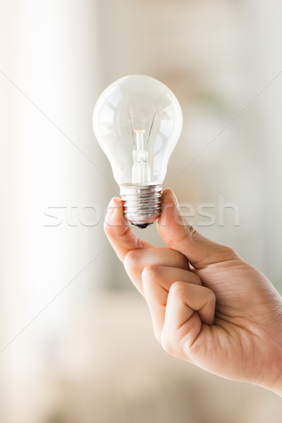 Stock photo: close up of hand holding edison lamp or lightbulb