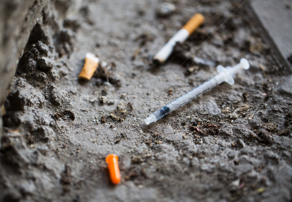close up of syringe and smoked cigarette on ground Stock photo © dolgachov