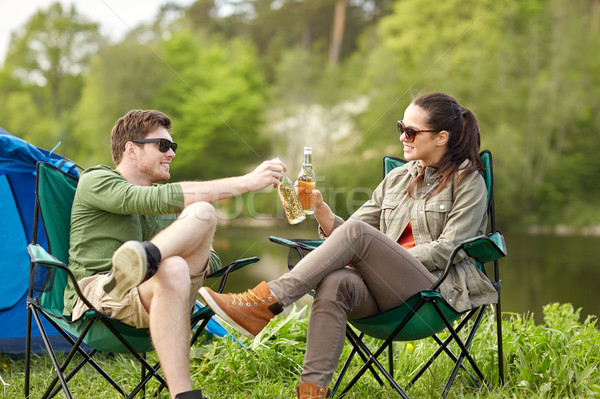 Stock photo: happy couple clinking drinks at campsite tent