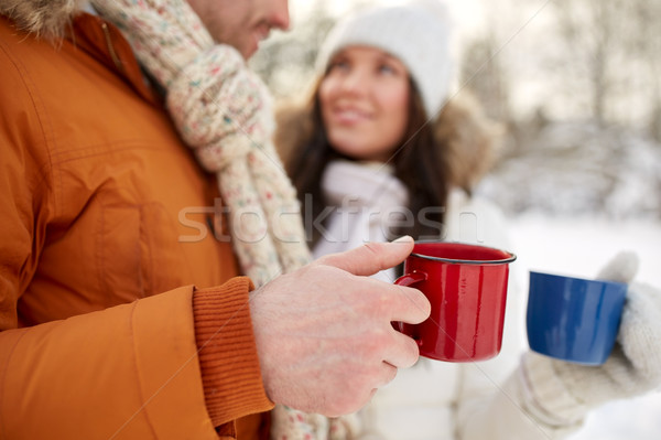 Stock photo: close up of happy couple with tea cups in winter