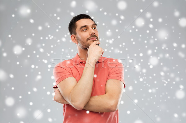 man in polo t-shirt thinking over snow background Stock photo © dolgachov