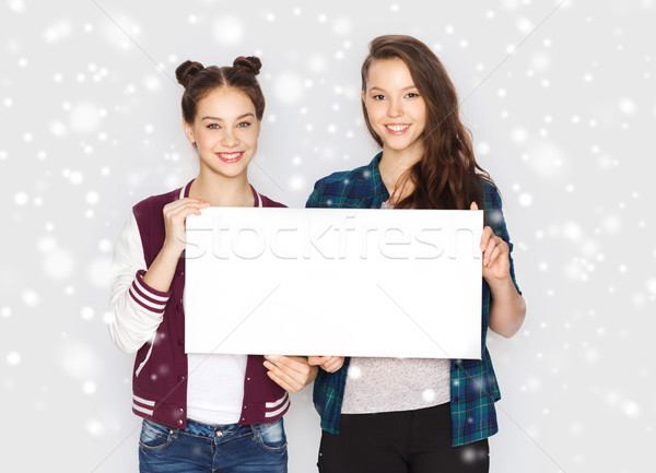 Stock photo: smiling teenage girls holding white blank board