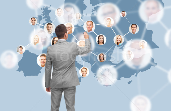 businessman at virtual screen with contacts Stock photo © dolgachov
