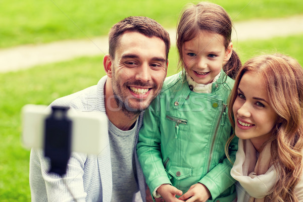 Stock photo: happy family taking selfie by smartphone outdoors