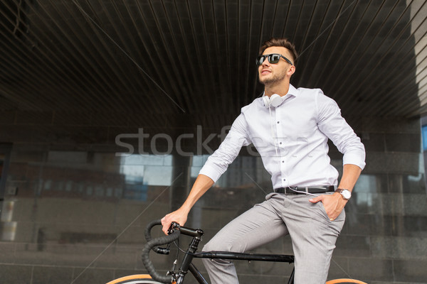 man with bicycle and headphones on city street Stock photo © dolgachov