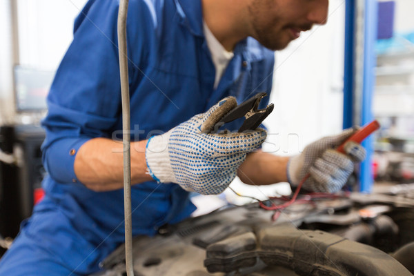 auto mechanic man with cleats charging battery Stock photo © dolgachov