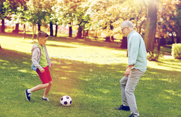 old man and boy playing football at summer park Stock photo © dolgachov