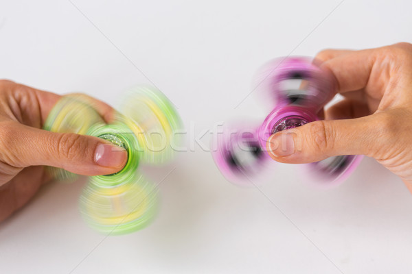 close up of hands playing with fidget spinners Stock photo © dolgachov