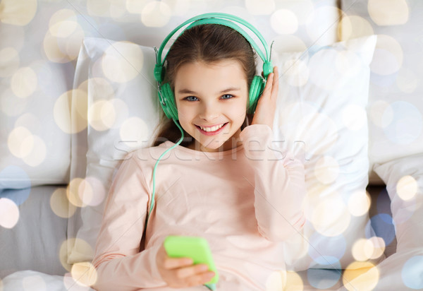 Ragazza cuffie ascoltare musica letto persone bambini Foto d'archivio © dolgachov