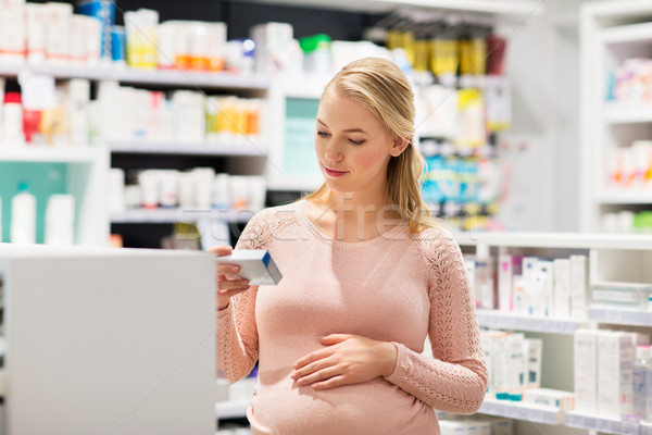 Stock photo: happy pregnant woman with medication at pharmacy