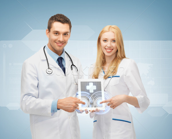 young doctors pointing at tablet pc Stock photo © dolgachov