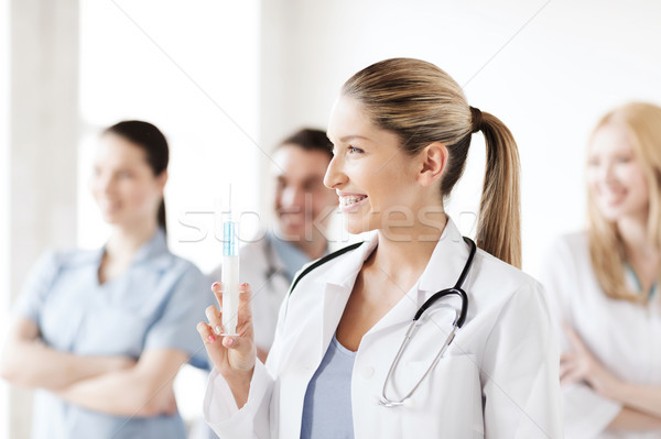 Stock photo: female doctor holding syringe with injection