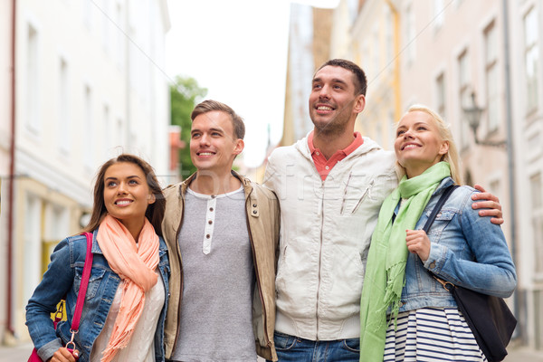 group of smiling friends walking in the city Stock photo © dolgachov