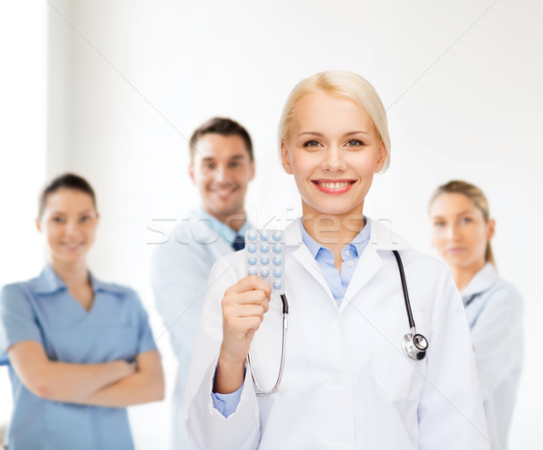 smiling female doctor with pills Stock photo © dolgachov