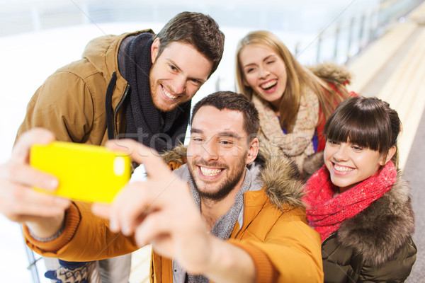 happy friends with smartphone on skating rink Stock photo © dolgachov