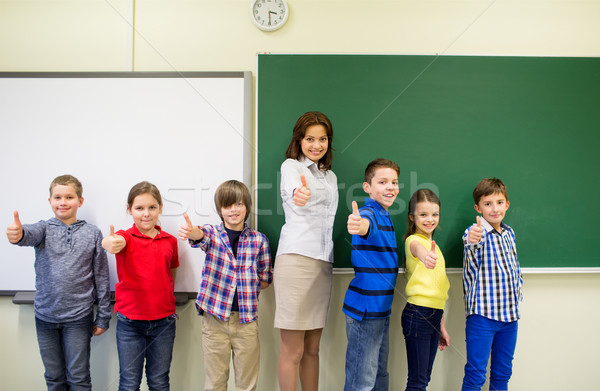 group of school kids and teacher showing thumbs up Stock photo © dolgachov