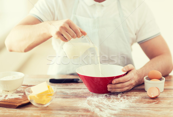 close up of male hand pouring milk in bowl Stock photo © dolgachov