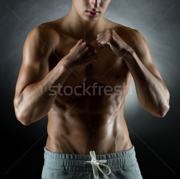 young man on fighting stand over black background Stock photo © dolgachov