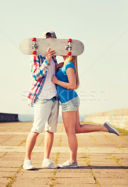 Stock photo: couple with skateboard kissing outdoors