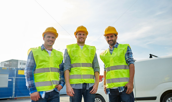 happy male builders in high visible vests outdoors Stock photo © dolgachov