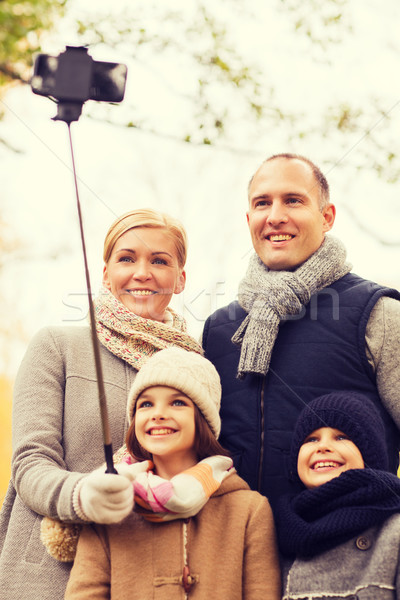 Stock photo: happy family with smartphone and monopod in park