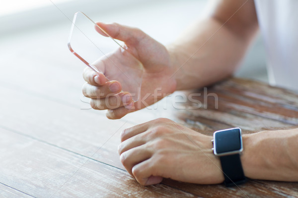 Stock photo: close up of hands with smart phone and watch